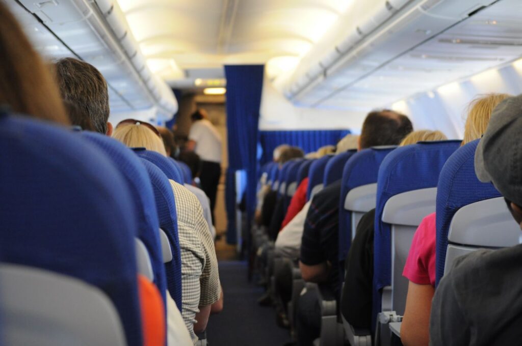 Interior view of an airplane cabin with passengers seated, showcasing air travel experience.